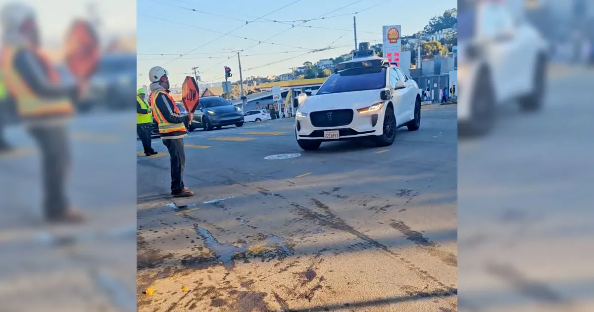 Taxi autonome Waymo déconcerté par les gestes d'un ouvrier du bâtiment.