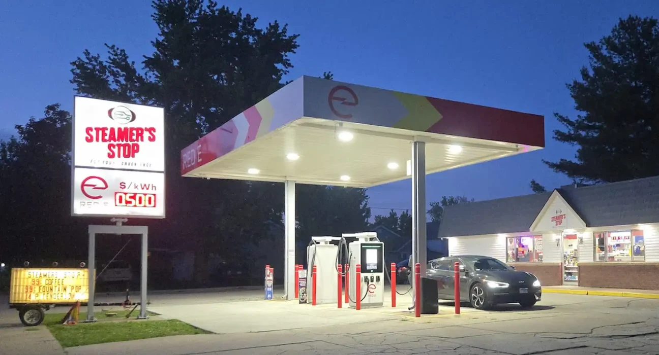 Conducteur électrique découvre la première station de charge entièrement électrique avec magasin et panneau de prix géant