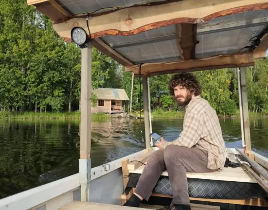 Un habitant insulaire construit un bateau solaire pour transporter son matériel à travers le lac et stationner devant chez lui.